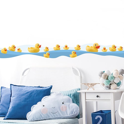 Sticker frise canards en pastique au bord de l'eau dans chambre d'enfant avec coussins bleus