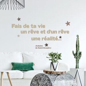Sticker citation - Phrase de Saint-Exupéry au-dessus d'un canapé blanc - "Fais de ta vie un rêve et d'un rêve une réalité"