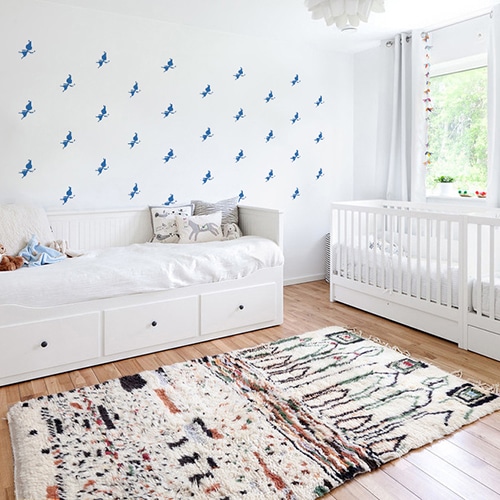 Mosaïque de stickers fées bleues sur mur blanc dans une chambre de bébé