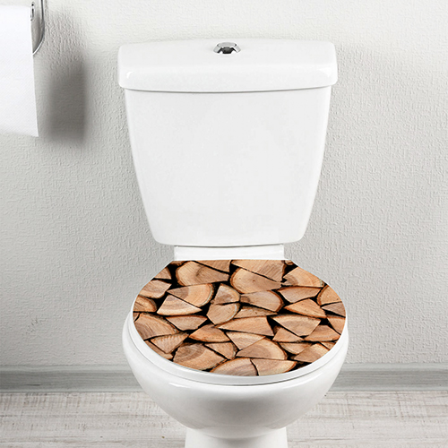 Siège de toilette décoré avec un sticker adhésif buches coupées