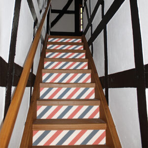 Escalier traditionnel dont les contremarches sont mises en valeur par des stickers autocollants bleus blancs rouges