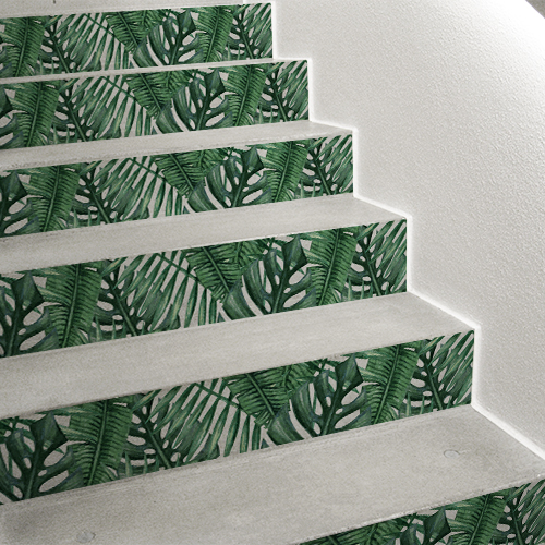Un escalier moderne se personnalise facilement avec des adhésifs pour contremarches d'escaliers au motif exotique de feuilles tropicales vert et blanc.