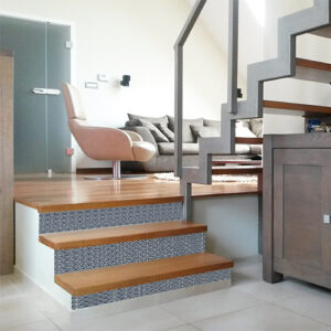 Découvrez comment les contremarches adhésives écailles bleu Japon personnalisent à merveille une montée d'escalier de bois clair.