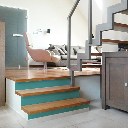 le bleu canard des contremarches d'escalier unie bleu s'accord parfaitement avec les marches d'escalier en bois clair.