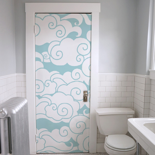 Salle de WC dont la porte est décorée par un sticker autocollant nuages blancs