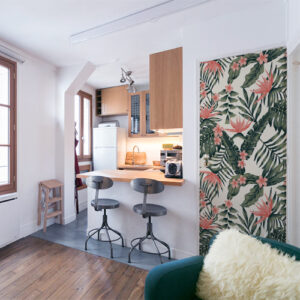 cuisine d'un appartement moderne sous les toits avec sticker motif fleurs exotiques roses collé sur la porte ce qui vient compléter le style tendance et le côté cosy de cet intérieur